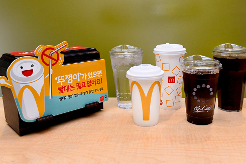 '뚜껑이 있으면 빨대는 필요 없어요'라는 문구와 함께 다양한 맥도날드 컵이 진열된 이미지.