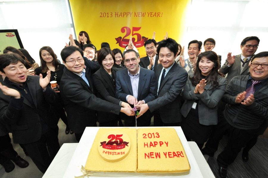 맥도날드 한국 진출 25주년 기념 케이크를 임직원들이 함께 자르는 모습