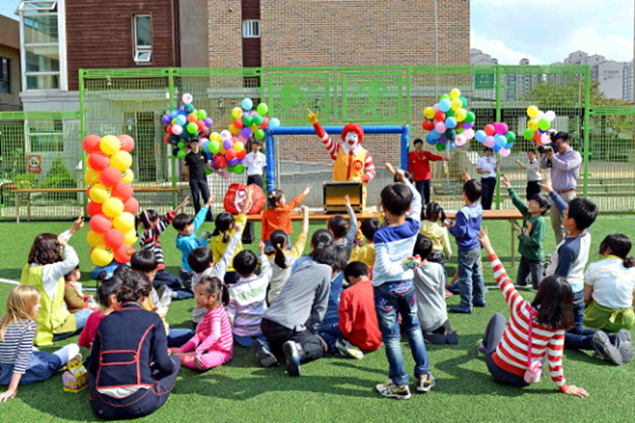 다문화 가정 어린이 축구교실 프로그램으로 야외 행사장에서 어린이들이 풍선과 함께 놀이 활동하는 모습