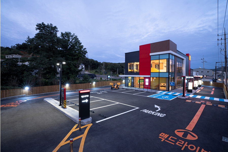 차량 2대가 나란히 동시에 주문할 수 있는 맥도날드 드라이브스루 매장과 야외 주차장 전경